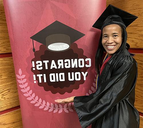 SNU 澳门太阳城官网, Lauren Morrison-Edwards, standing next to sign that says "Congrats, you did it!"