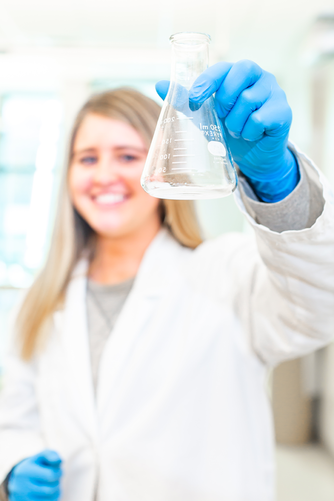 student holding beaker in science lab
